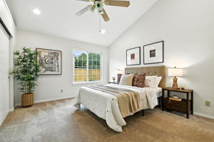 Primary bedroom with attached bath and vaulted ceilings
