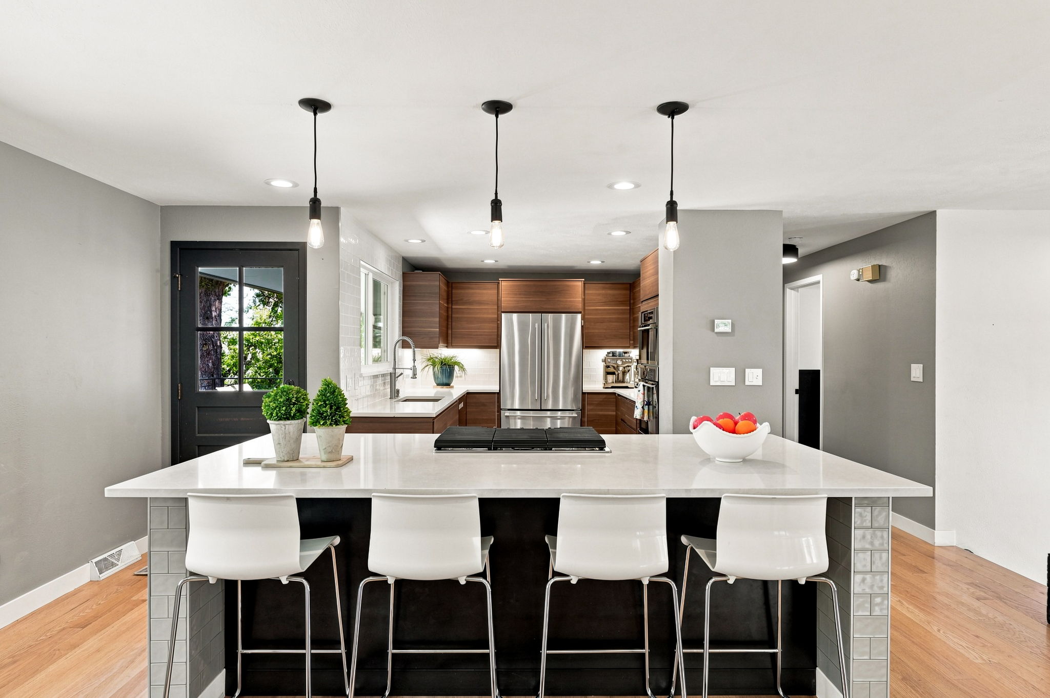 Remodeled kitchen with quartz counters, walnut cabinetry and a seated island.