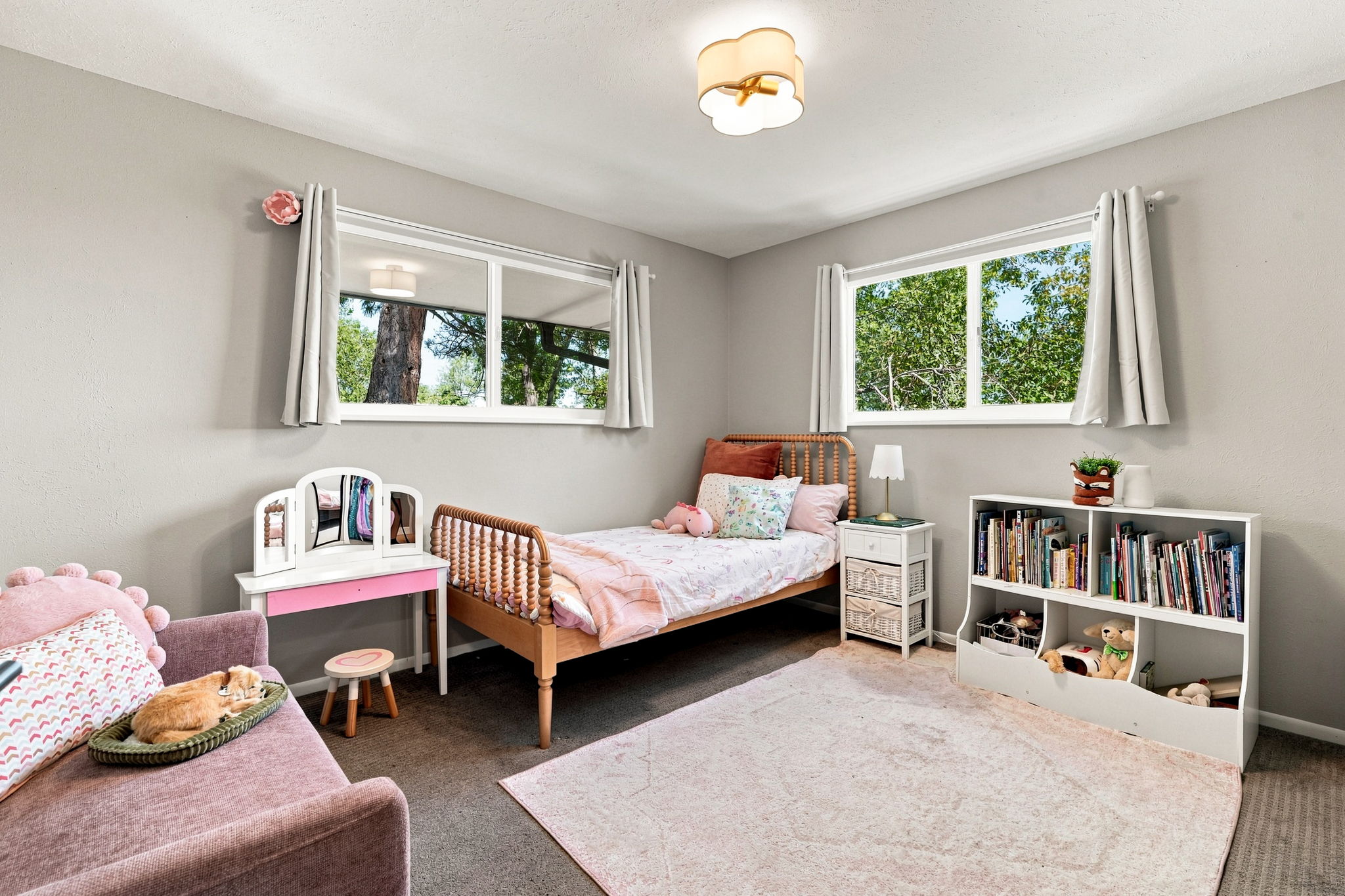 Second upstairs bedroom with newer windows, natural light, and trees all around.