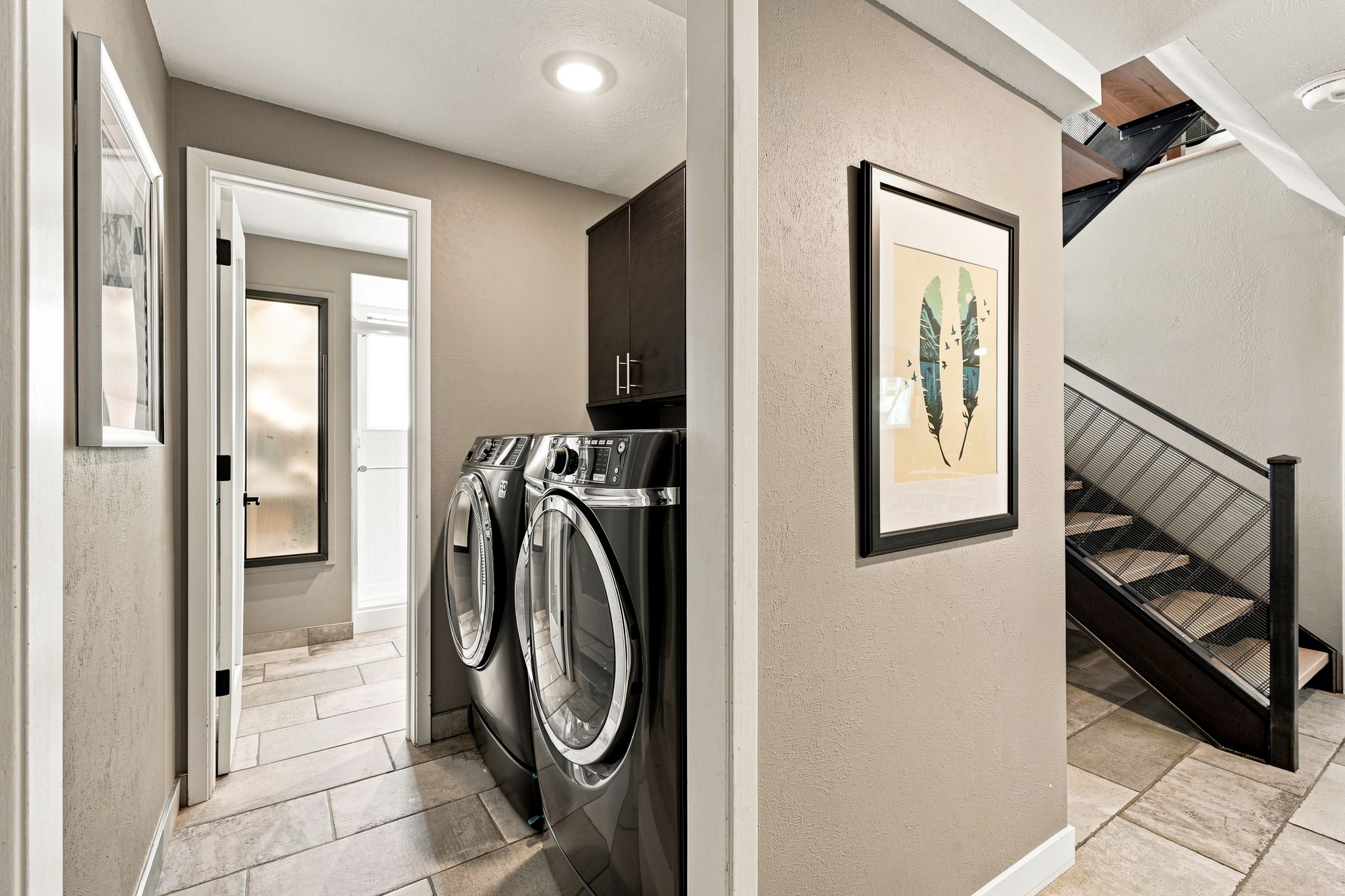 Full-size laundry with cabinetry and new washer/dryer just off the lower-level stairs.