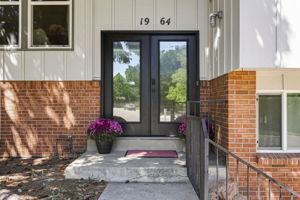Covered entry with custom black double doors.