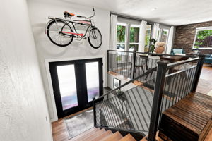 Steel mesh railing and open treads carry the architectural detail upstairs.