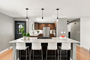 Remodeled kitchen with quartz counters, walnut cabinetry and a seated island.