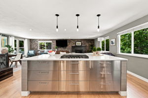 Stainless island opens directly to the living room and fireplace.