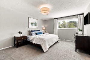 Primary bedroom with treed views and generous natural light.