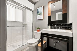 Third full bath on the lower level with a subway-tiled shower.