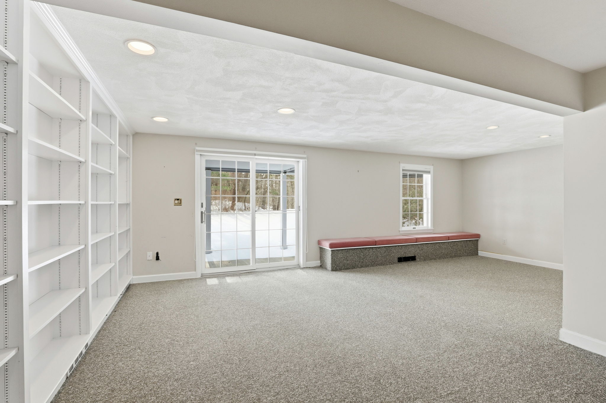 Family Room, Lower Level I | With exterior access via slider, custom shelving & window seat