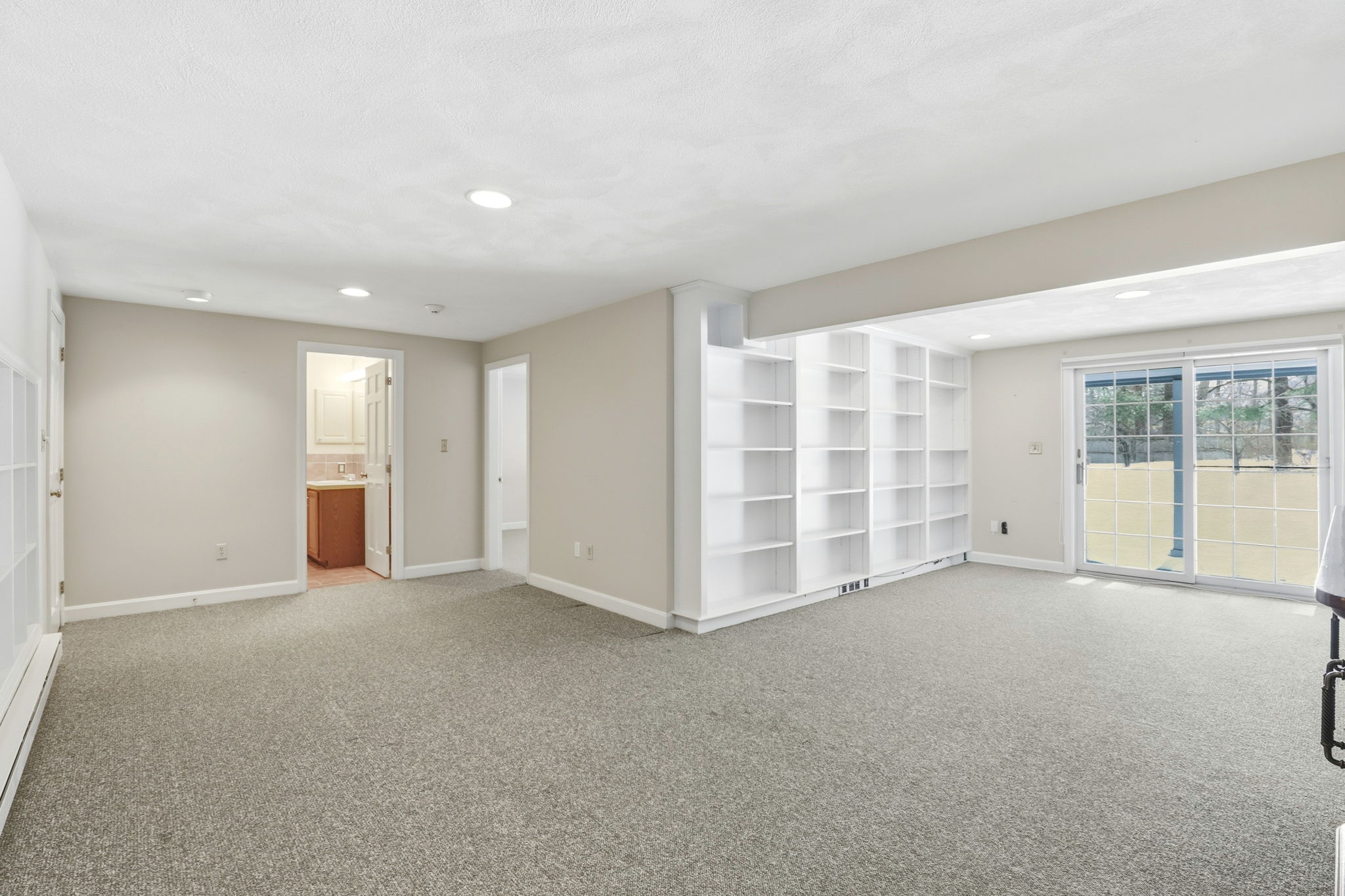Family Room, Lower Level IV | With exterior access via slider and custom shelving