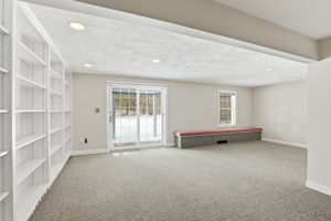 Family Room, Lower Level I | With exterior access via slider, custom shelving & window seat