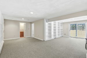 Family Room, Lower Level IV | With exterior access via slider and custom shelving
