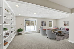 Family Room, Lower Level I (Virtually Staged) | With exterior access via slider, custom shelving & window seat
