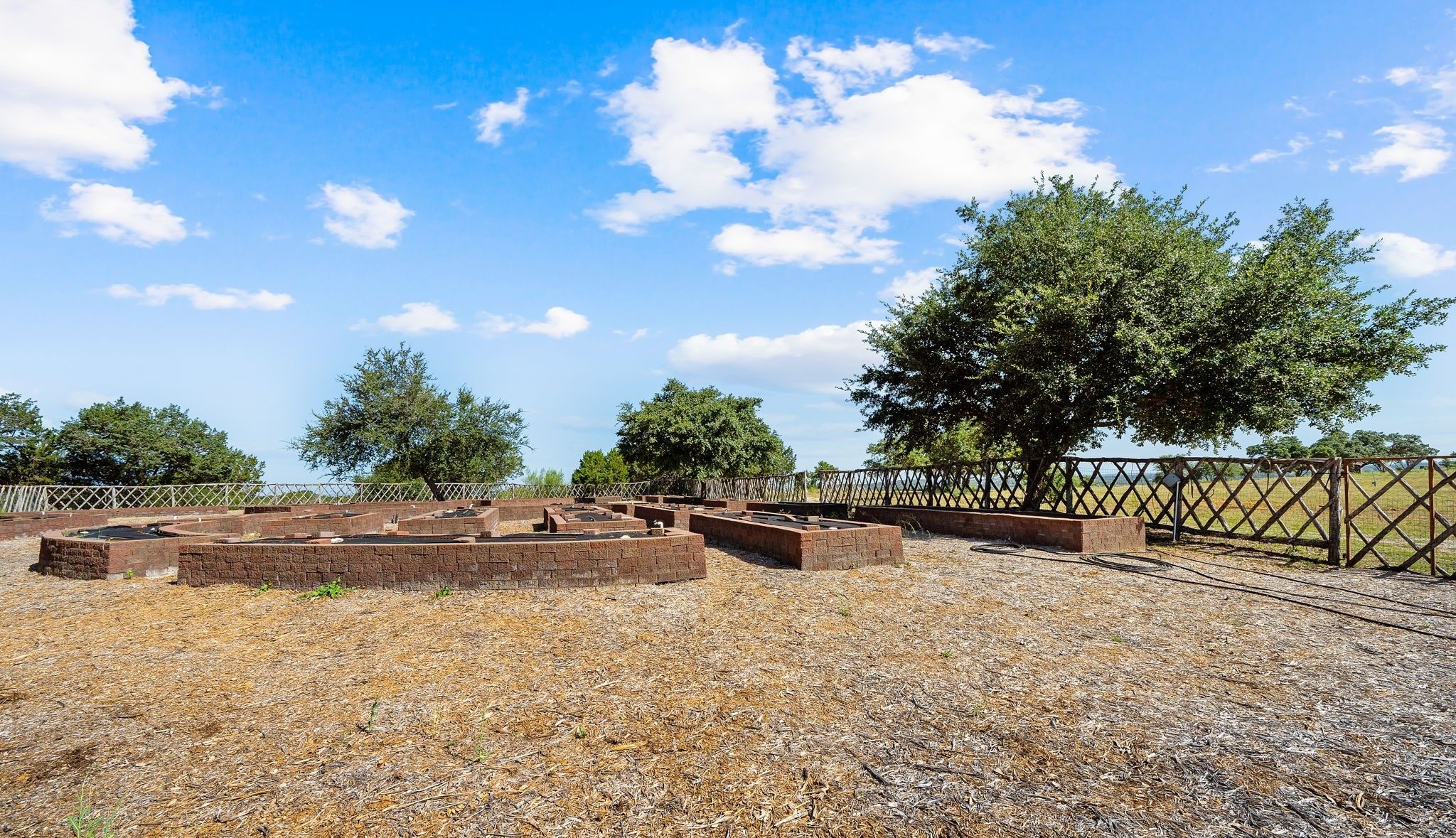 Fenced Organic Garden has 47 raised beds with 3 ft high Belgard Pavers and an Irrigation System.