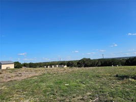 Looking towards Lakeway, you see the entrance gate to your property and the larger well house with storage.