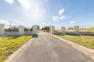 Grand Entrance Gate within the gated subdivision to your private property of 23.85 acres. Garden Beds align both sides of the entrance. A High Game Fence surrounds the acreage except for the waterfront area.