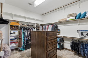 Oversized primary suite walk-in closet with triple rods and built-in dressers. There is also another large walk-in closet in the primary suite if the owners want separate or off-season wardrobe access.