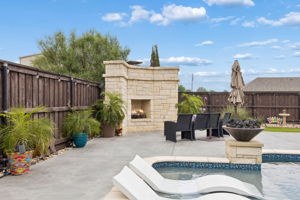 Statement stone fireplace, tanning ledge and fireballs for added accents to your hardscape aesthetics.