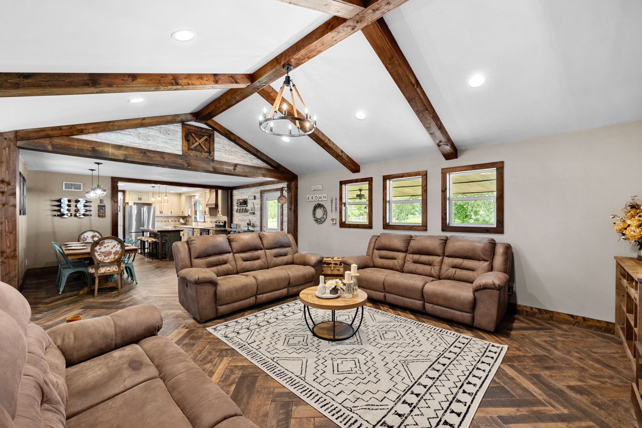 The Great Room boasts an amazing open floor plan with vaulted and beamed ceilings, a no maintenance electric fireplace, and a view of the gorgeous backyard.