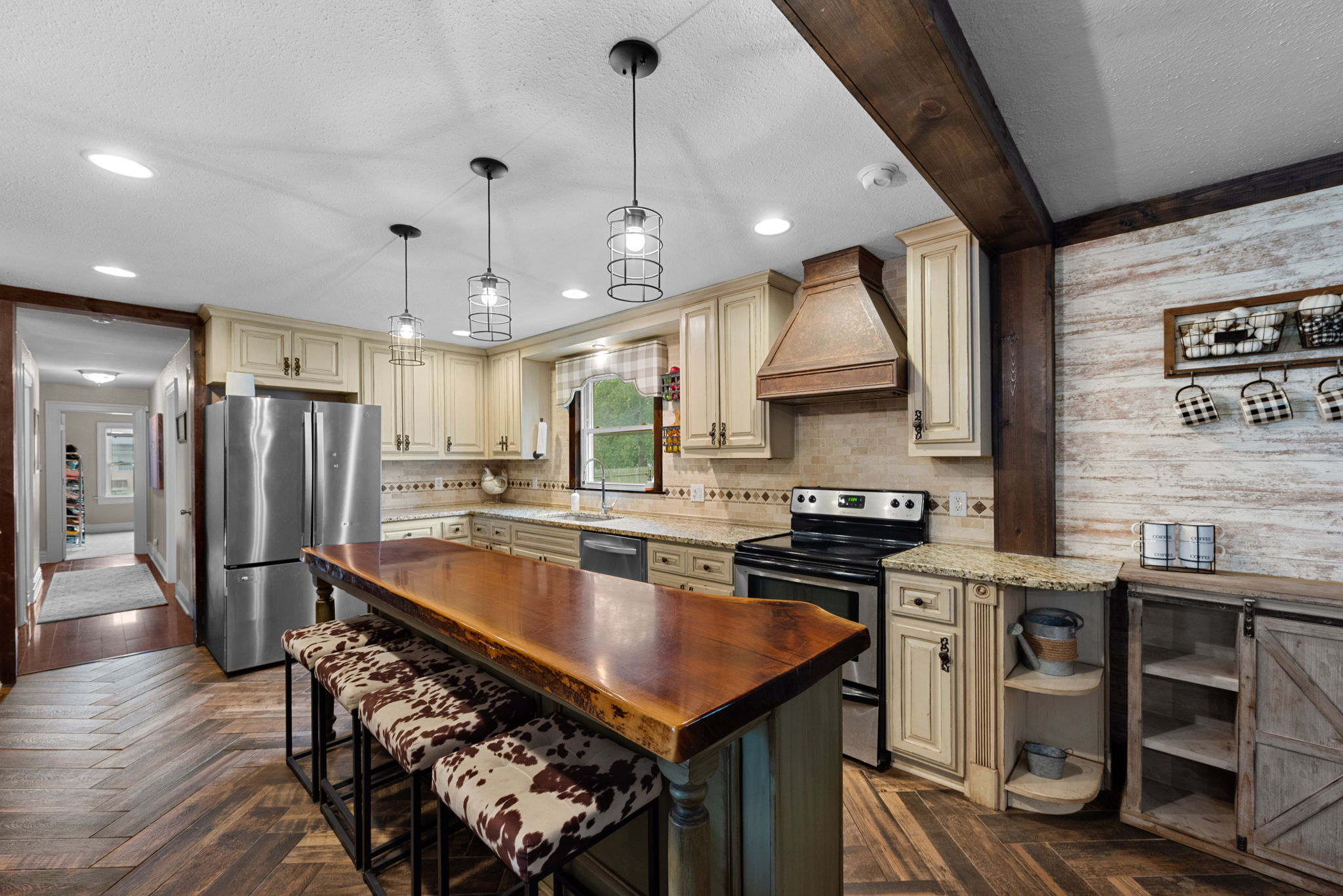 The kitchen features a breathtaking live edge walnut island that was painstakingly sliced and beautifully stained. If rustic elegance is your aesthetic? You will be in heaven in this home!