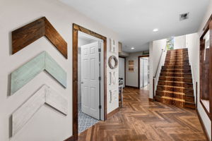 Heading back to the other side of the foyer you will find a half bath and access to the 4 car garage, main floor laundry room, and the extra wide staircase to the 2nd story living area.