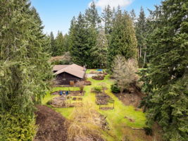 This gorgeous corner lot property has so many areas to explore! You will appreciate the mature landscaping where you will find fruit trees, lawn, a fire pit, private retreat hideaways, garden beds, peek a boo Olympic Mountain views, and so much more!