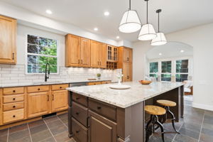 The large island with seating, plentiful cabinet storage, and included appliances-these are the details that matter.