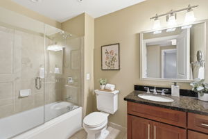 The spacious bathroom has lovely finishes, incl.