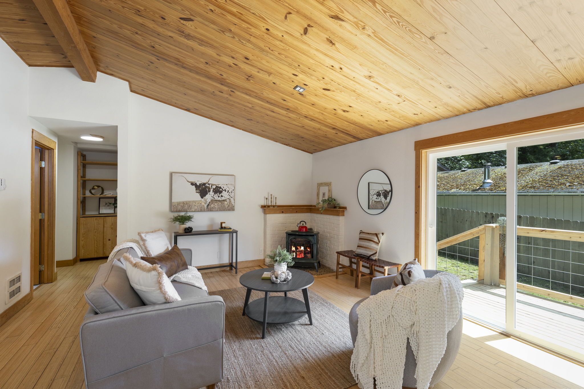 Such a warm and inviting living space with free standing propane stove and sliding glass door to deck.