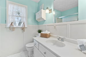 Tall wainscoting accents the guest bath...
