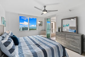 Serene primary bedroom featuring water views and abundant natural light