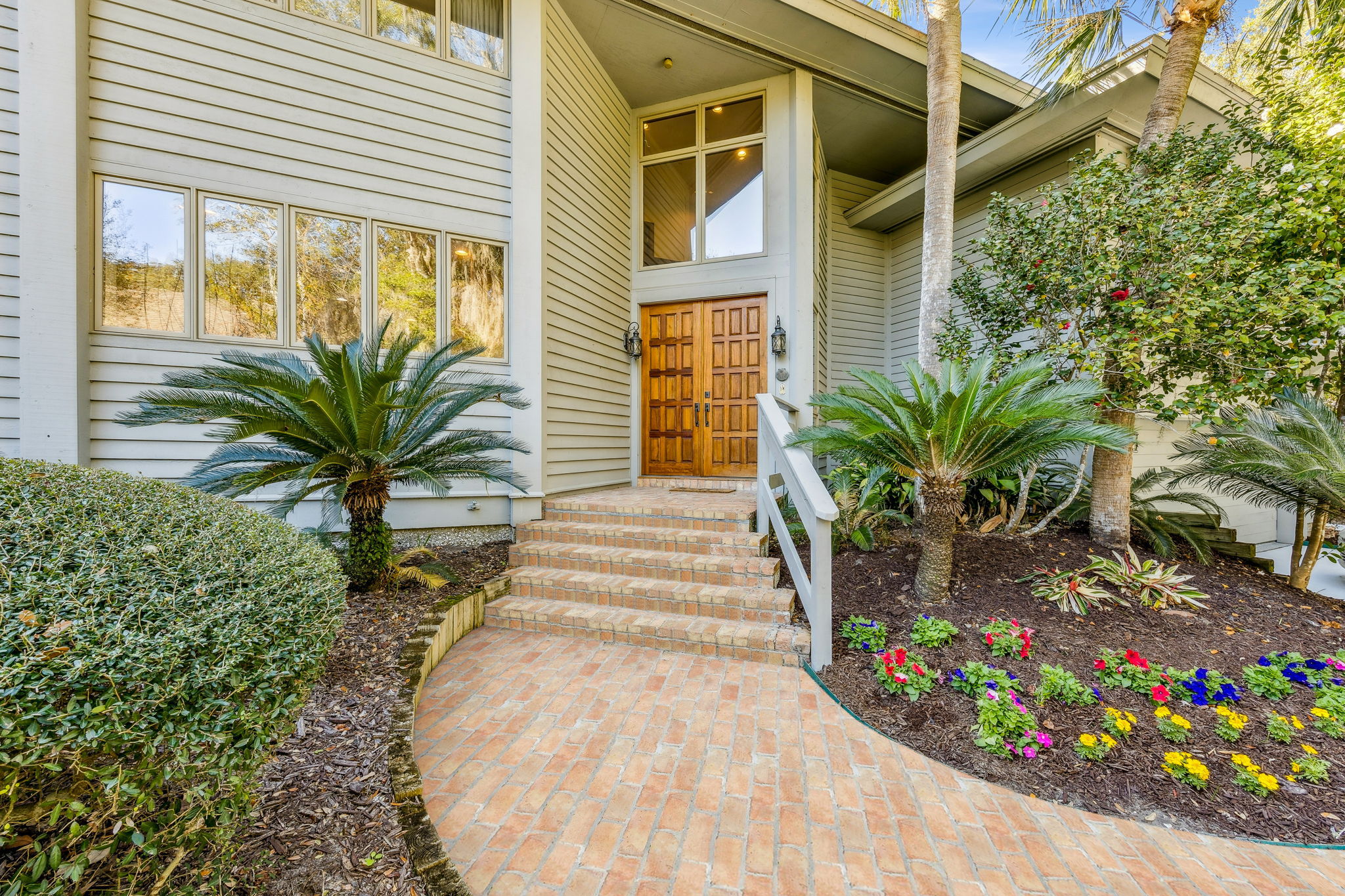 Striking custom mahogany double doors set a warm, elegant first impression.