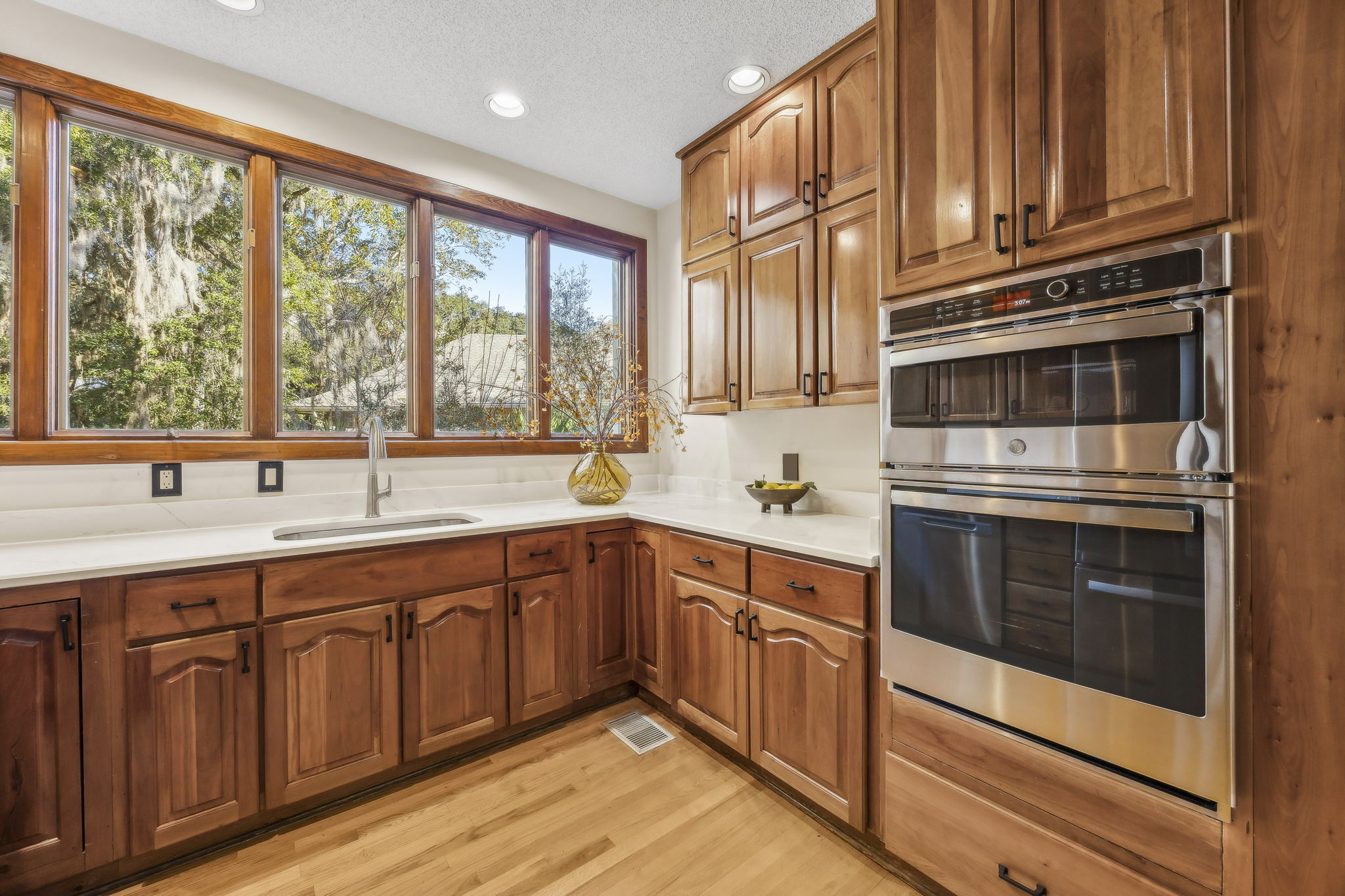 ... the kitchen features rich cherry cabinets, new stainless steel appliances, and quartz countertops.