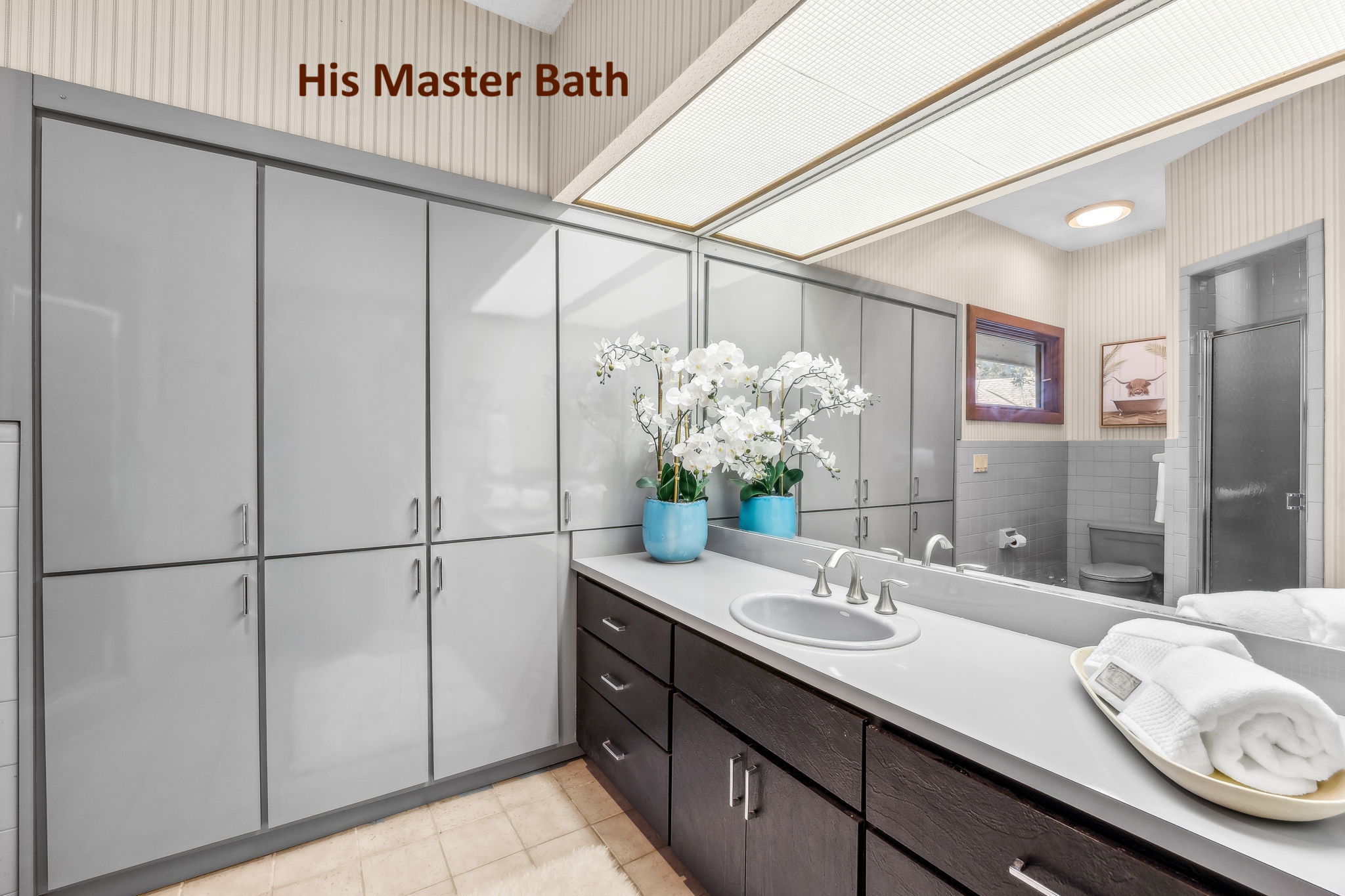 His bath: featuring a walk-in shower and custom built-in cabinetry.