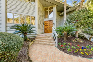 Striking custom mahogany double doors set a warm, elegant first impression.