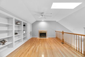 Loft offers hardwood floors and gas fireplace with marble surround and custom  built-in bookcase