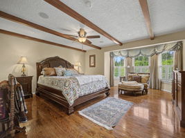 Primary bedroom with beamed ceilings, french doors to hall