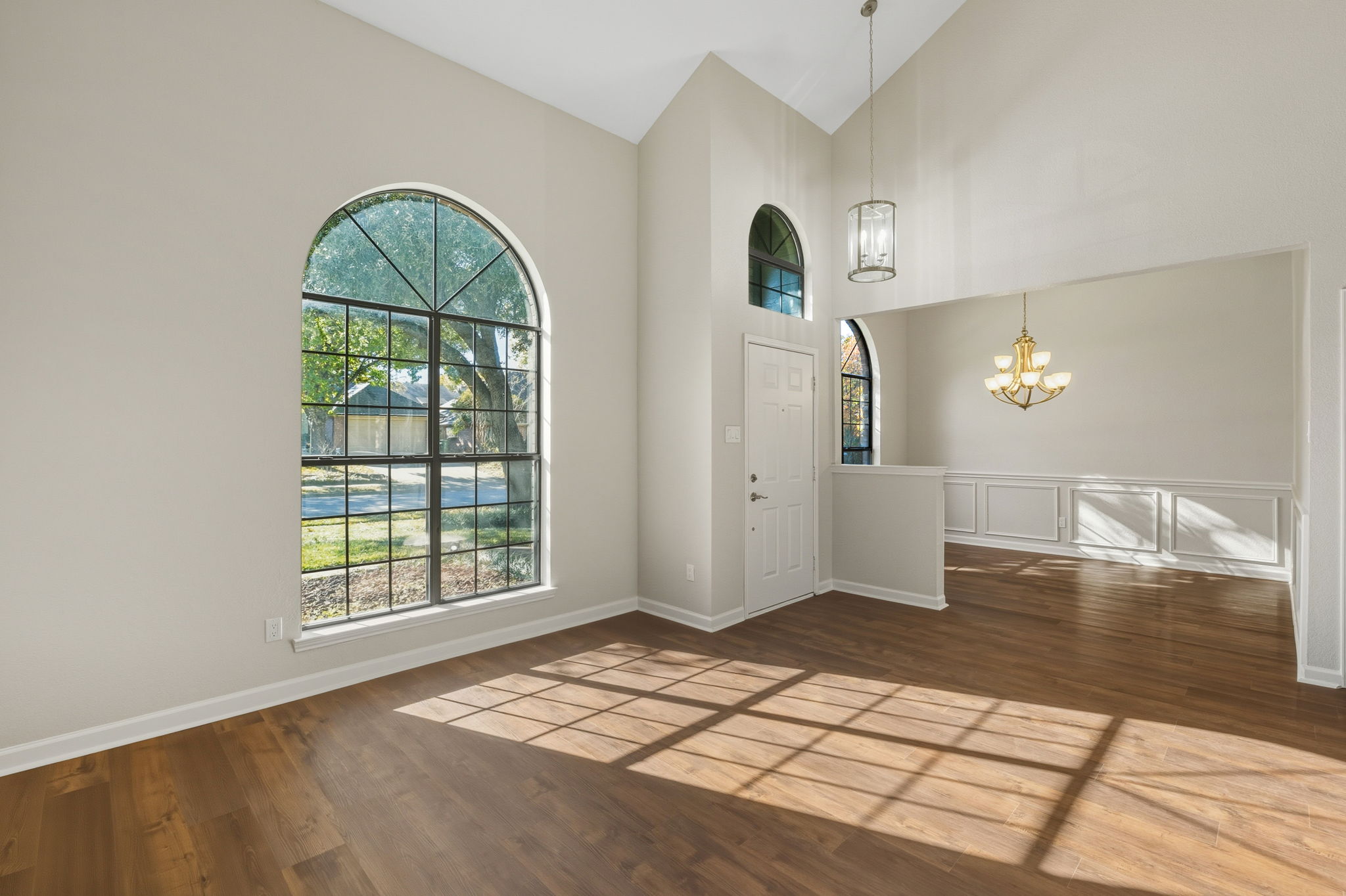The formal living room & Open Formal Dining Room with soaring ceilings that offer architectural drama and new Luxury Vinyl Flooring