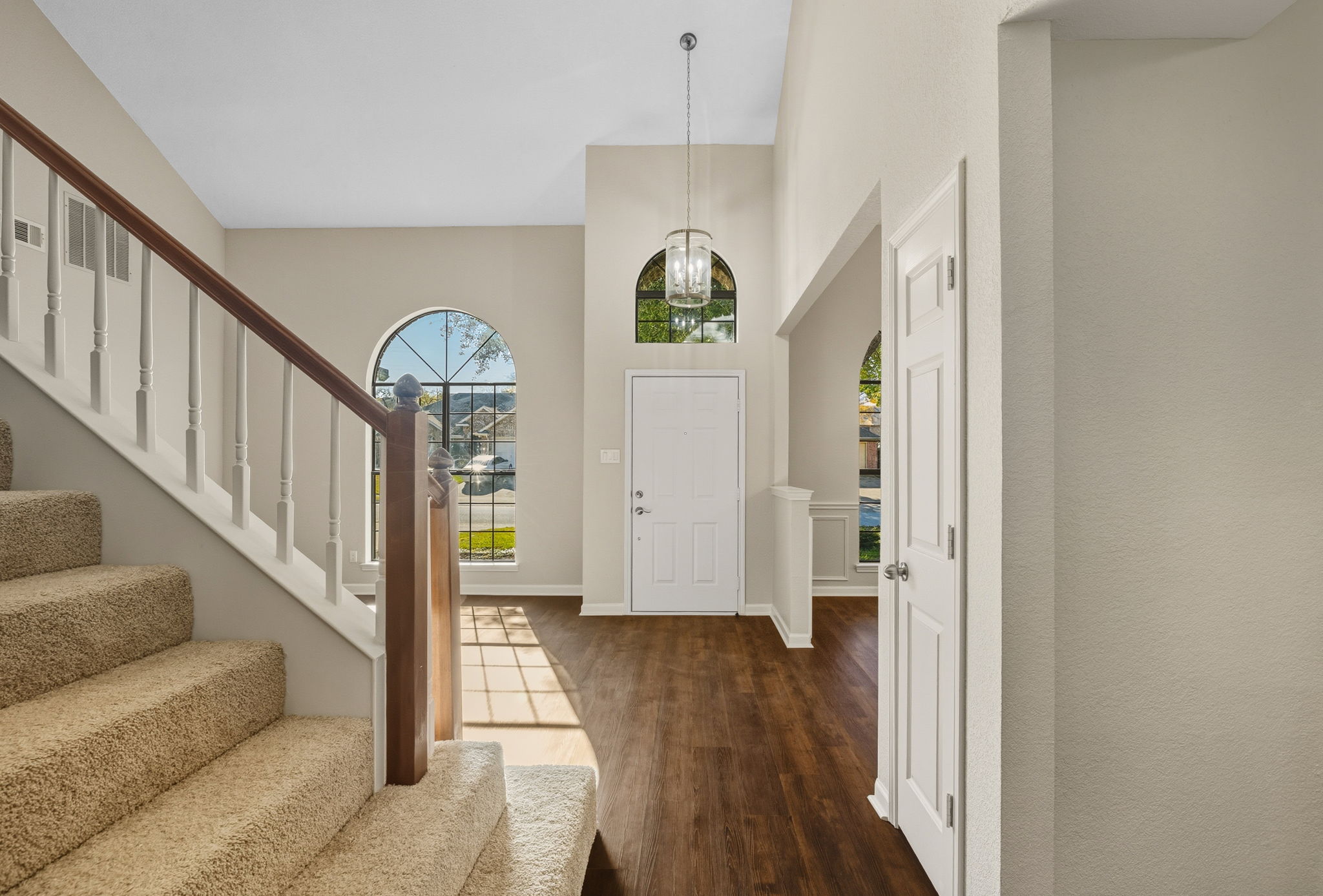 Front Entrance with Tall Vaulted Ceiling and Newly Carpeted Stairs to Upper Level.