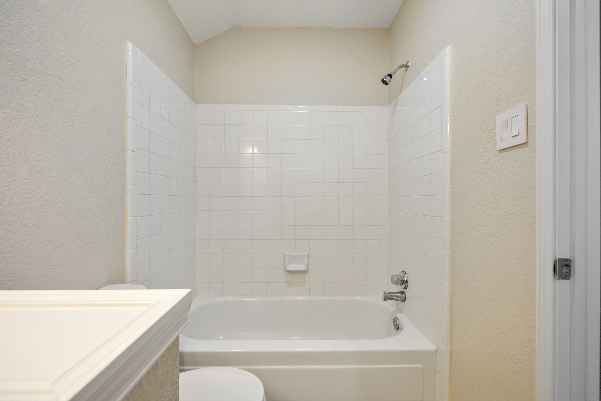 Freshly updated upstairs bathroom with tub/shower combo; featuring new paint and modern lighting.