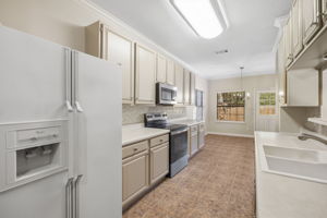 Bright and functional kitchen featuring newly painted cabinets, generous counter space for everyday cooking or entertaining, and a charming breakfast nook overlooking the backyard.