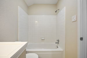 Freshly updated upstairs bathroom with tub/shower combo; featuring new paint and modern lighting.