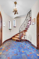 Graceful curved staircase with hand hammered iron railing