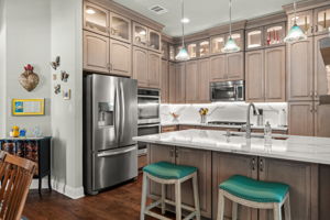 Gourmet kitchen boasts stainless steel appliances, double ovens, built in microwave, and quartz counter tops