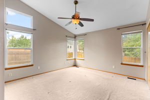 Vaulted primary bedroom with clerstory window