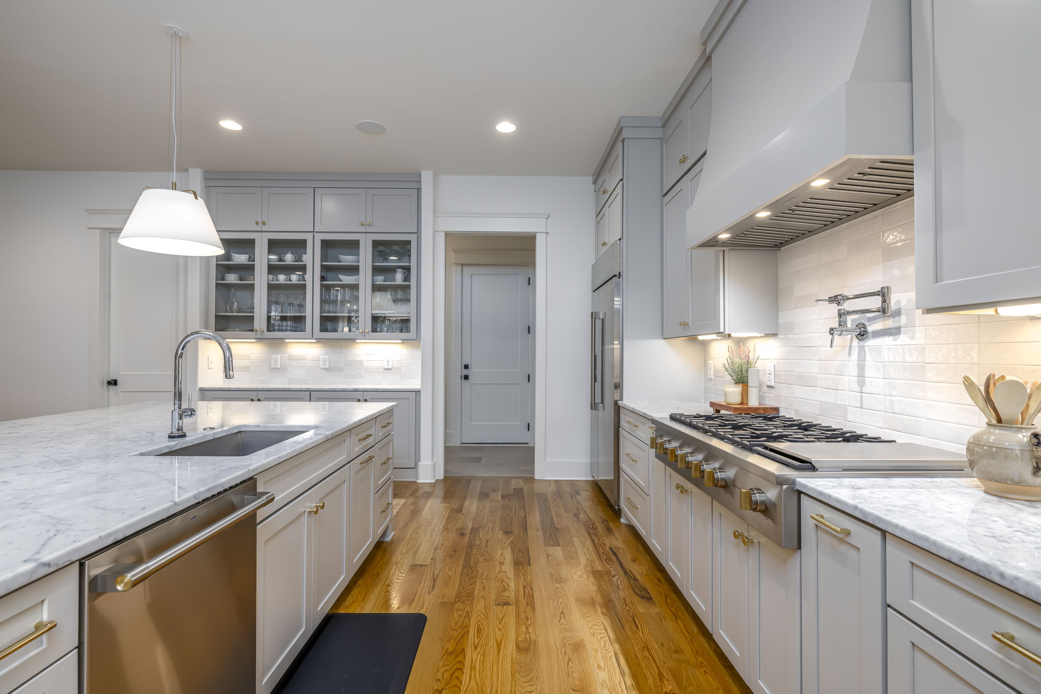 Kitchen cabinets include spice racks, utensil drawer, & baking sheet organization