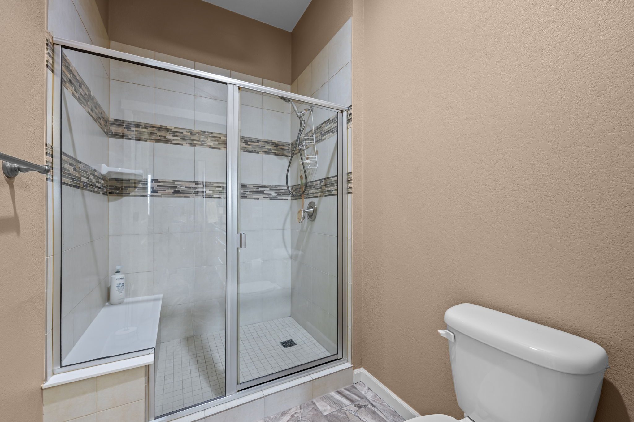 Primary shower with ceramic tile accent & 10 ft ceilings
