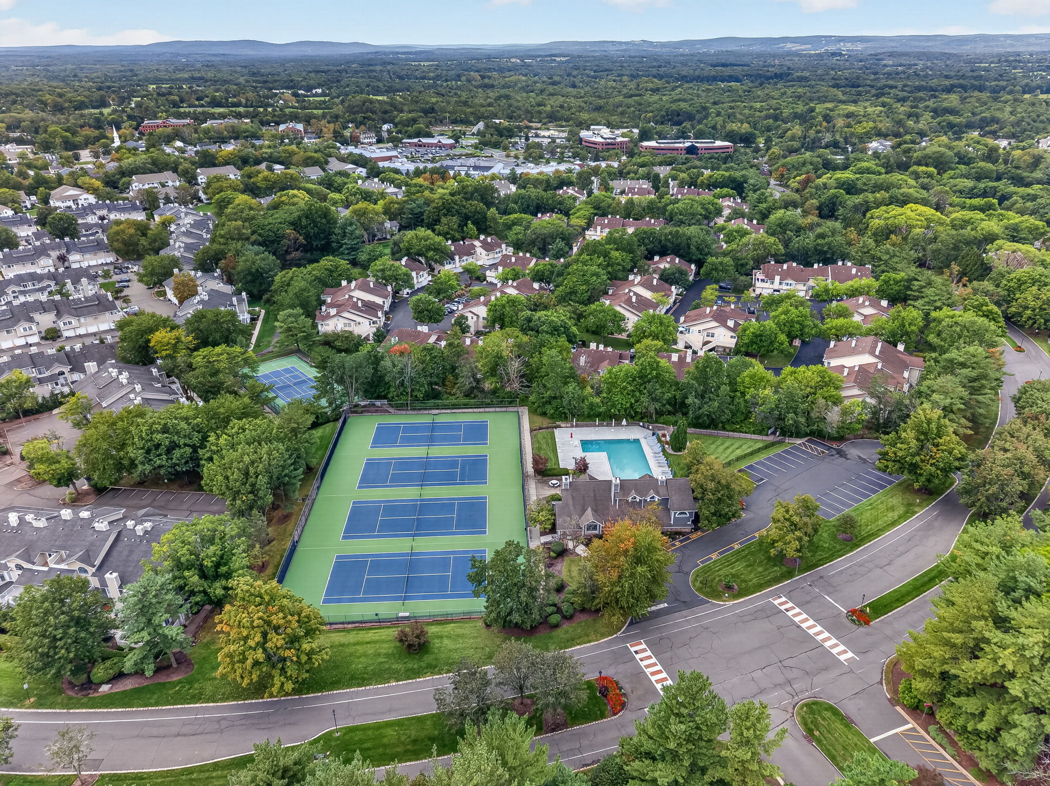 COMMUNITY PICTURE Residents of The Hills enjoy an array of amenities including a pool, tennis courts, clubhouse and fitness center, all within a beautifully maintained community setting.