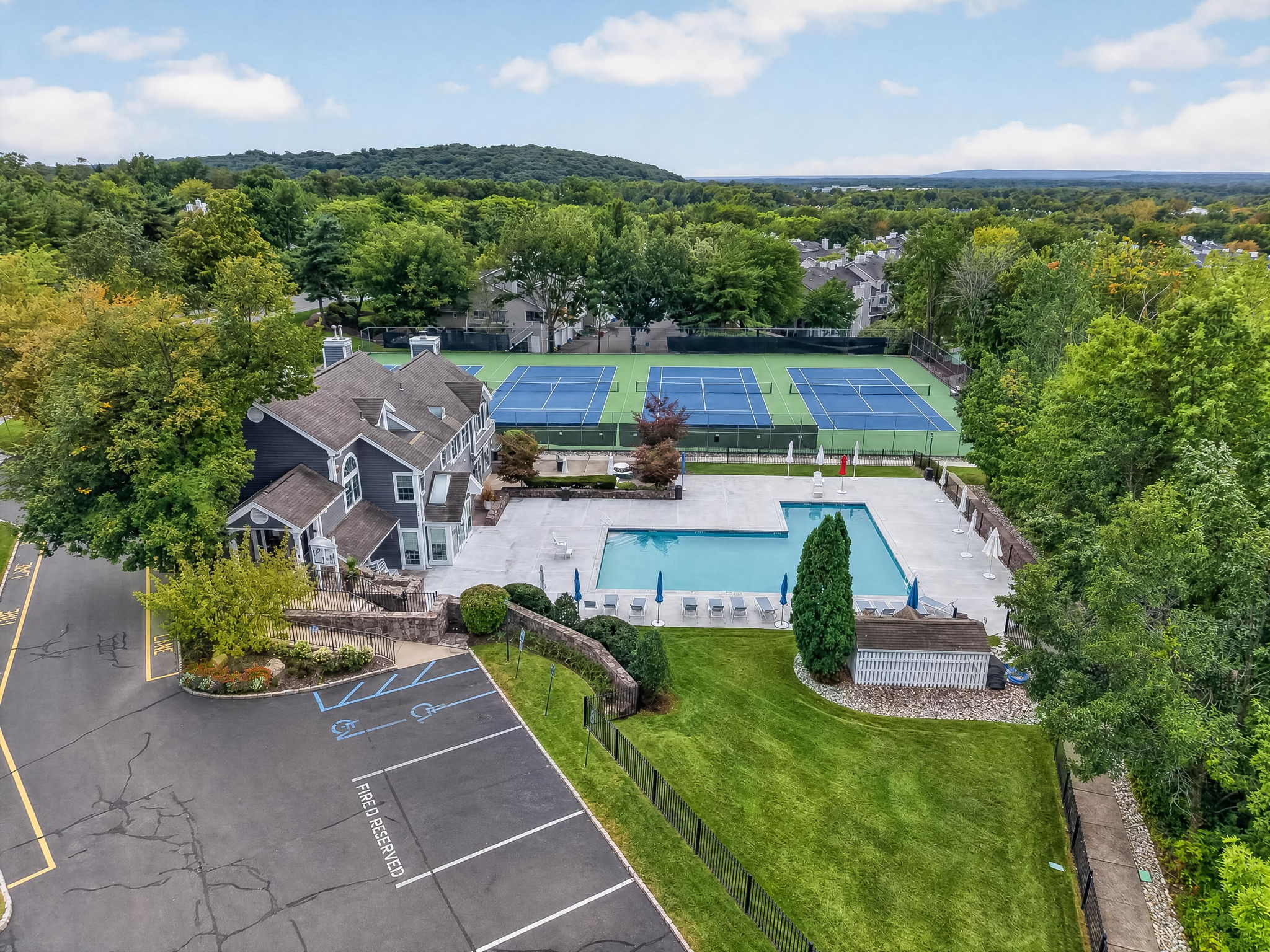 COMMUNITY PICTURE Residents of The Hills enjoy an array of amenities including a pool, tennis courts, clubhouse and fitness center, all within a beautifully maintained community setting.