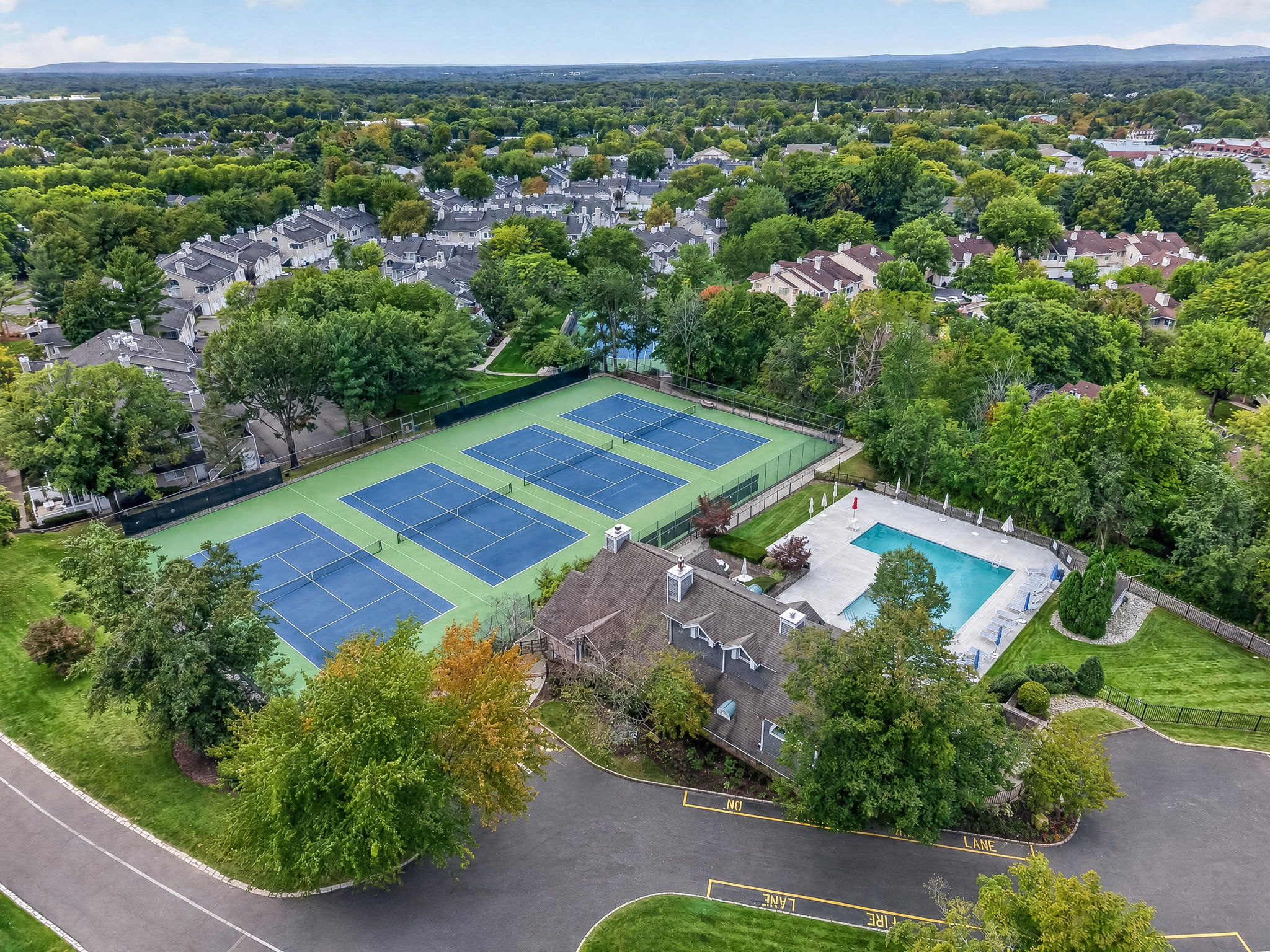 COMMUNITY PICTURE Residents of The Hills enjoy an array of amenities including a pool, tennis courts, clubhouse and fitness center, all within a beautifully maintained community setting.