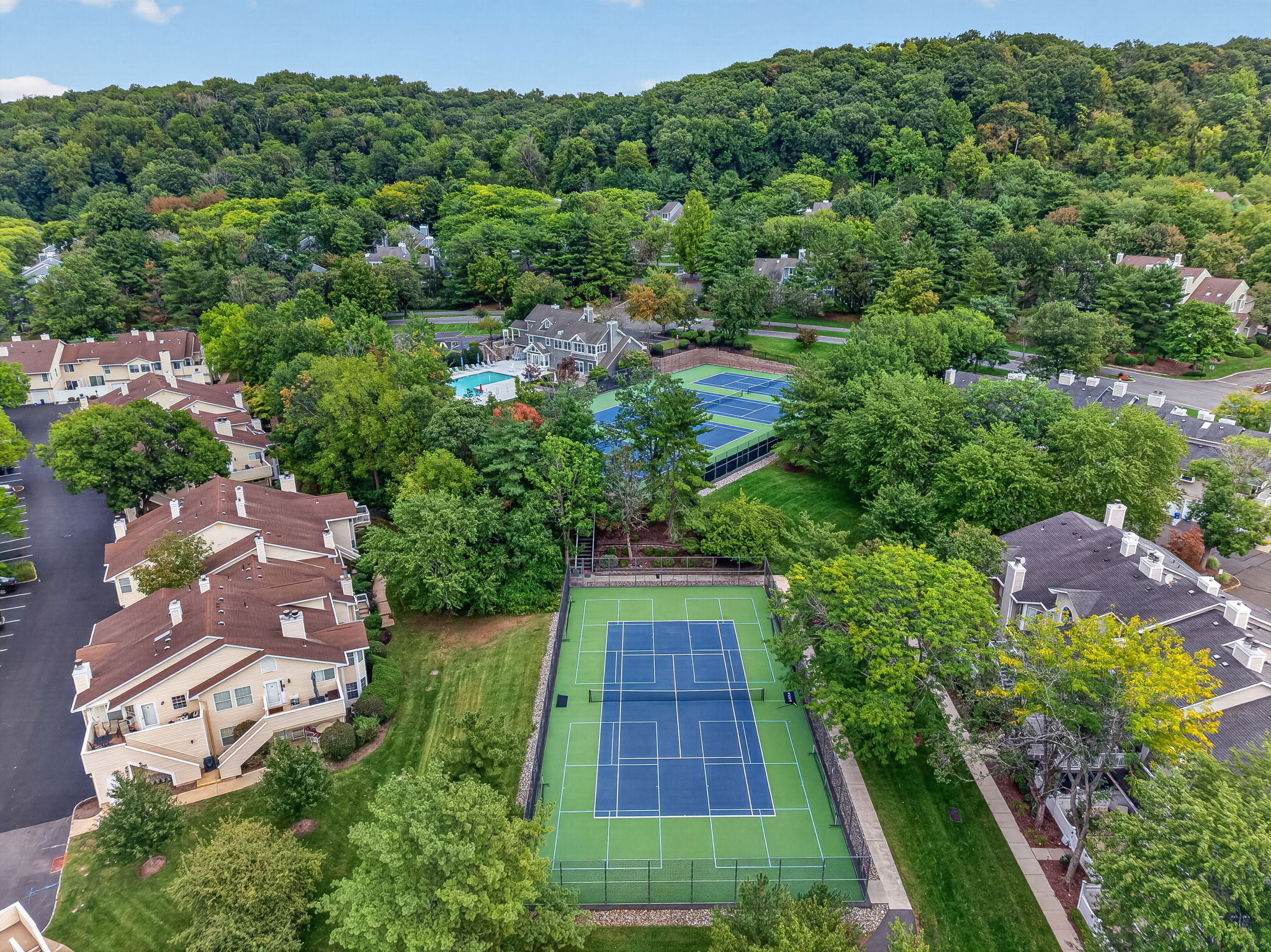 COMMUNITY PICTURE Residents of The Hills enjoy an array of amenities including a pool, tennis courts, clubhouse and fitness center, all within a beautifully maintained community setting.