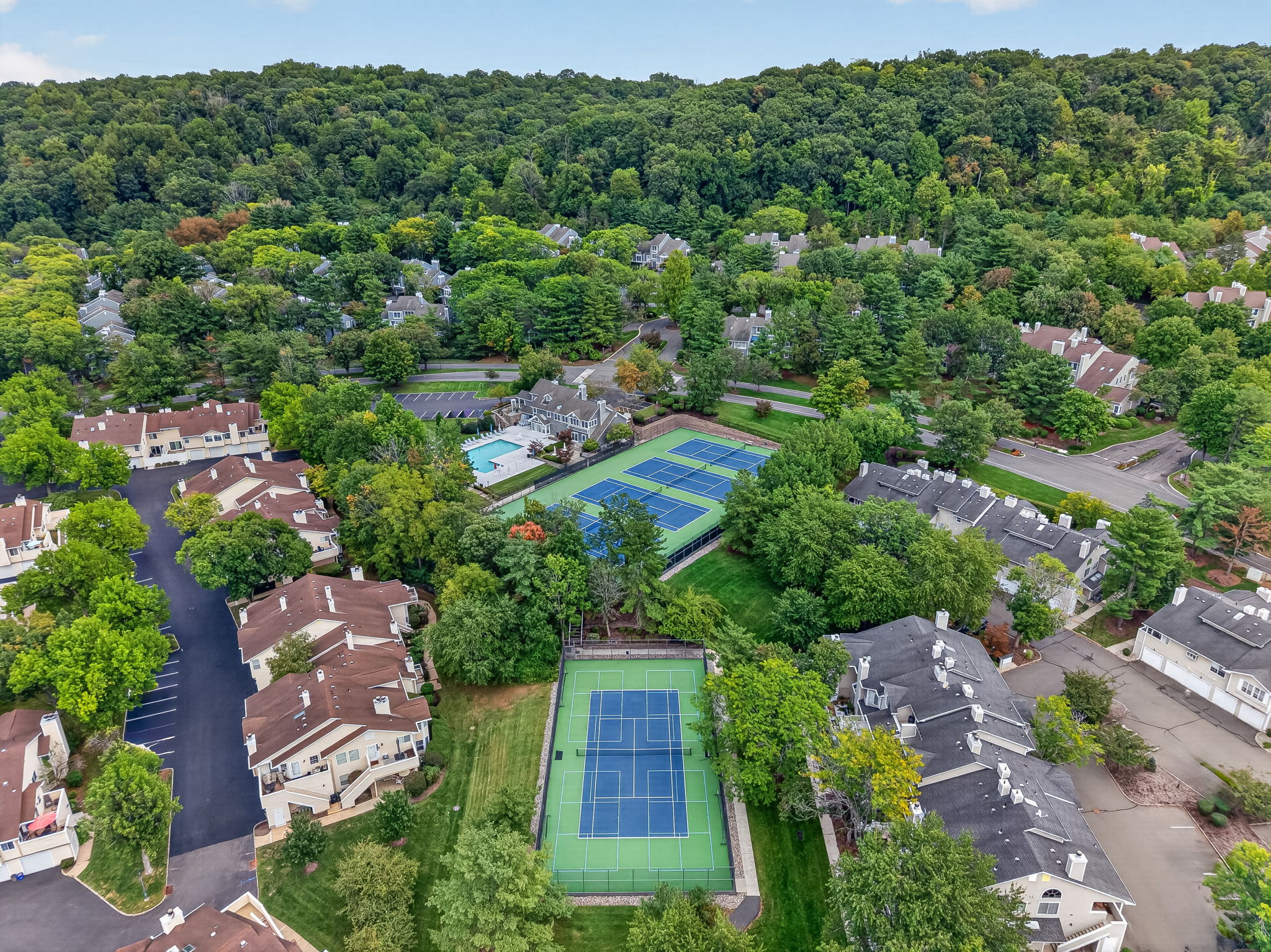 COMMUNITY PICTURE Residents of The Hills enjoy an array of amenities including a pool, tennis courts, clubhouse and fitness center, all within a beautifully maintained community setting.